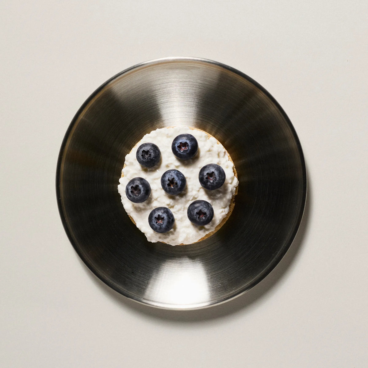 A Subtle Snacks Hint of Salt protein rice cake topped with cottage cheese and blueberries, a high-protein, low-calorie snack