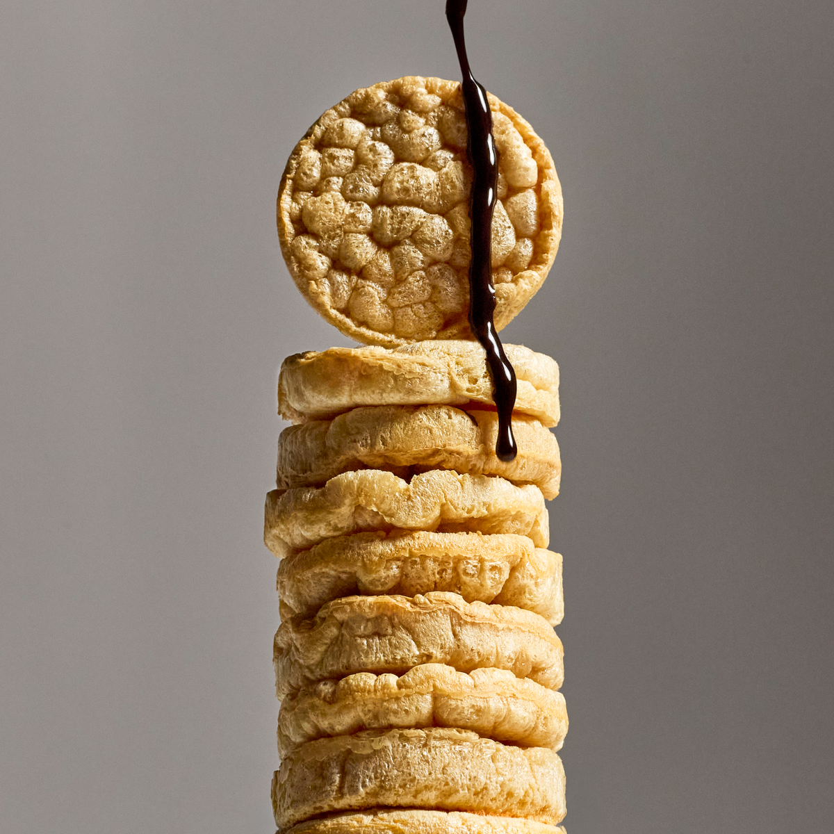 A tall stack of Subtle protein rice cakes with a drizzle on top.